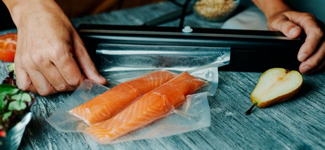 Vakuumbeutel wird mit frischem Lachs vakumiert